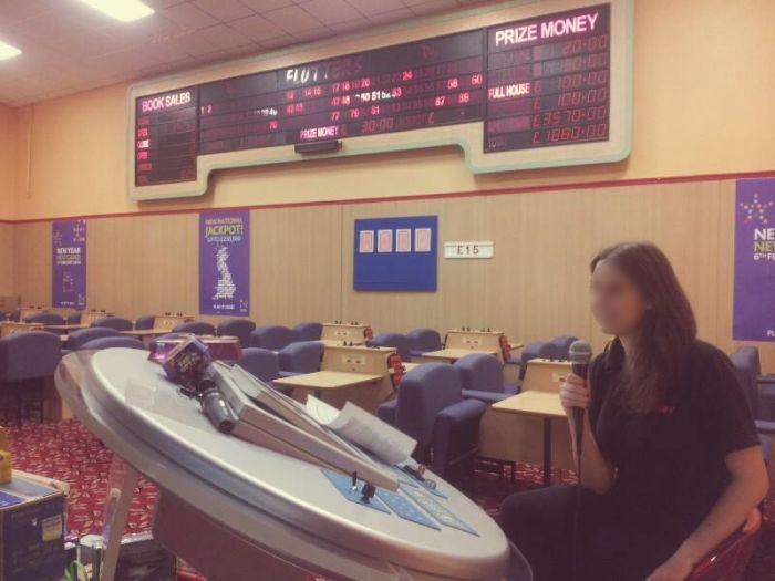 A friendly looking bingo caller announces the numbers