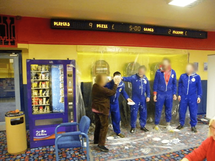 A customer puts a custard pie in a staff members face